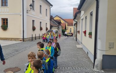 Prvošolci na pohodu in Črtek v mestu